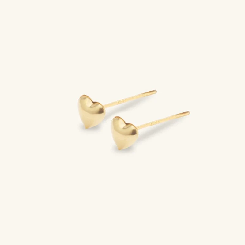 Glänzende goldene Herz-Ohrstecker